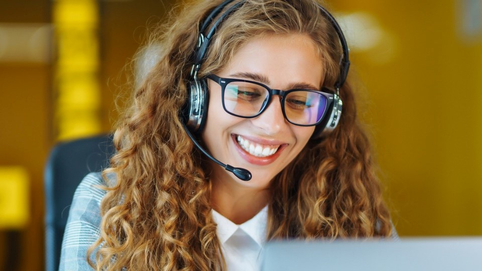 Customer service representative smiling while talking on phone