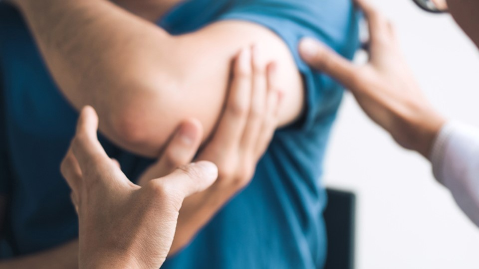 Physical therapists are checking patients elbows at the clinic office room.