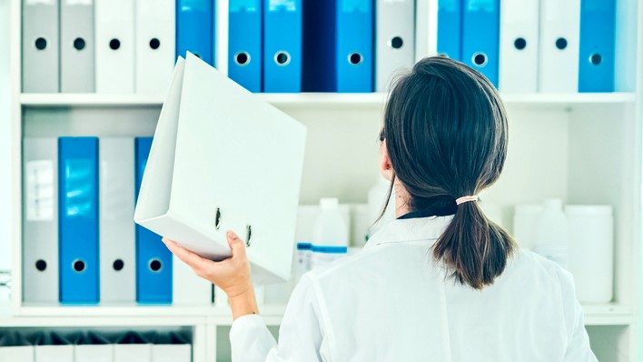 Doctor returning binder to shelf